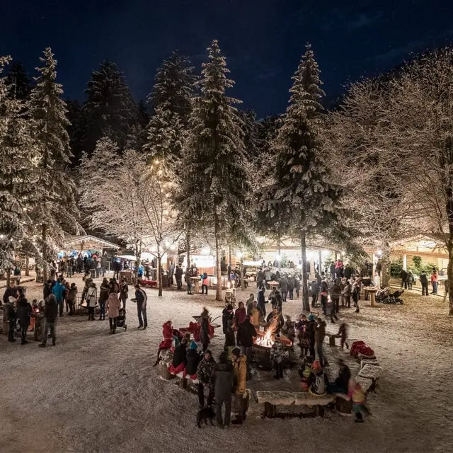 Winternacht mit festlichen Lichtern und Menschen