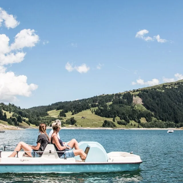 Zwei Personen auf einem Tretboot im See