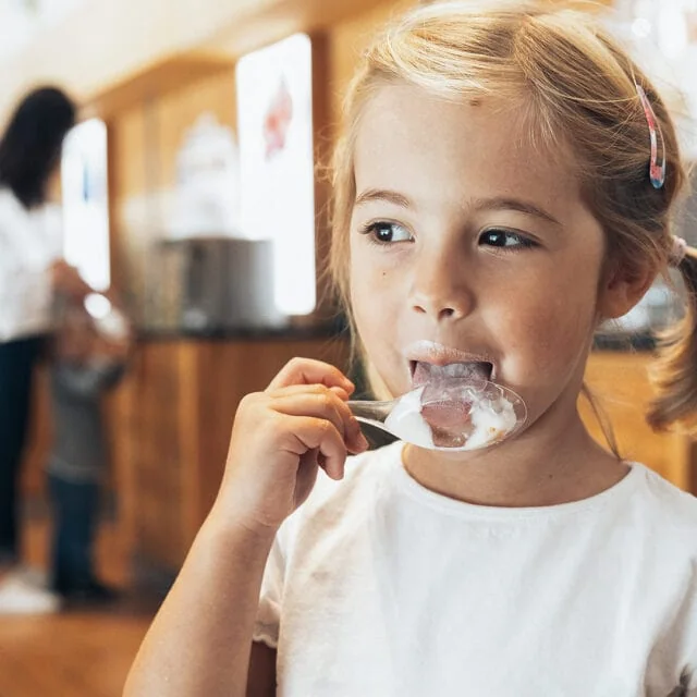 Mädchen genießt Eis in einem Eiscafé.