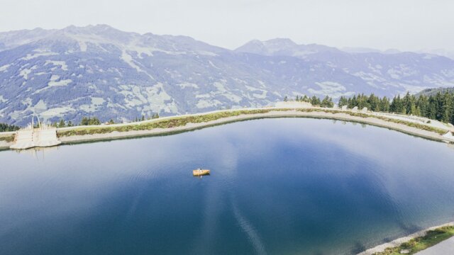Ruhiger See mit Boot und Berglandschaft
