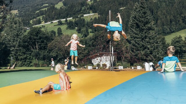 Kinder springen und spielen auf einem Trampolin.