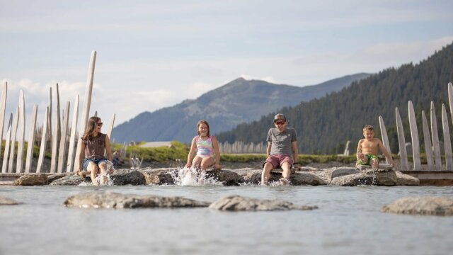 Familie spielt im Wasser bei sonnigem Wetter