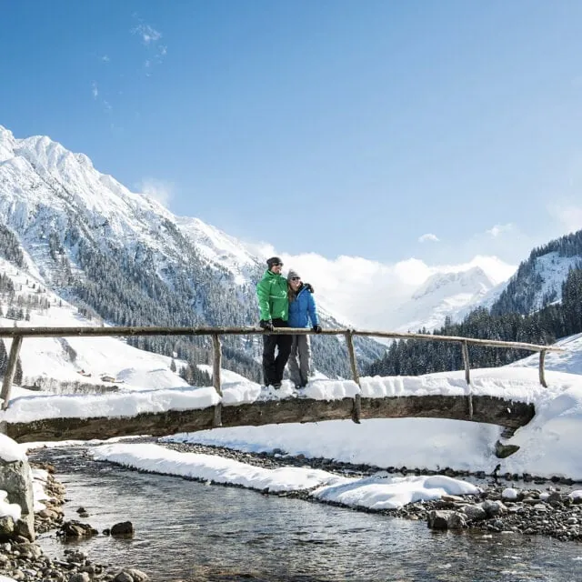 Paar auf einer Schneebrücke in den Bergen