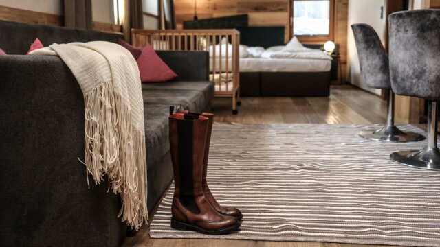 Gemütliches Wohnzimmer mit Stiefeln und Decke.