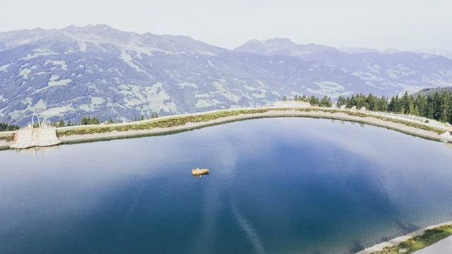 Ruhiger See mit Boot und Berglandschaft