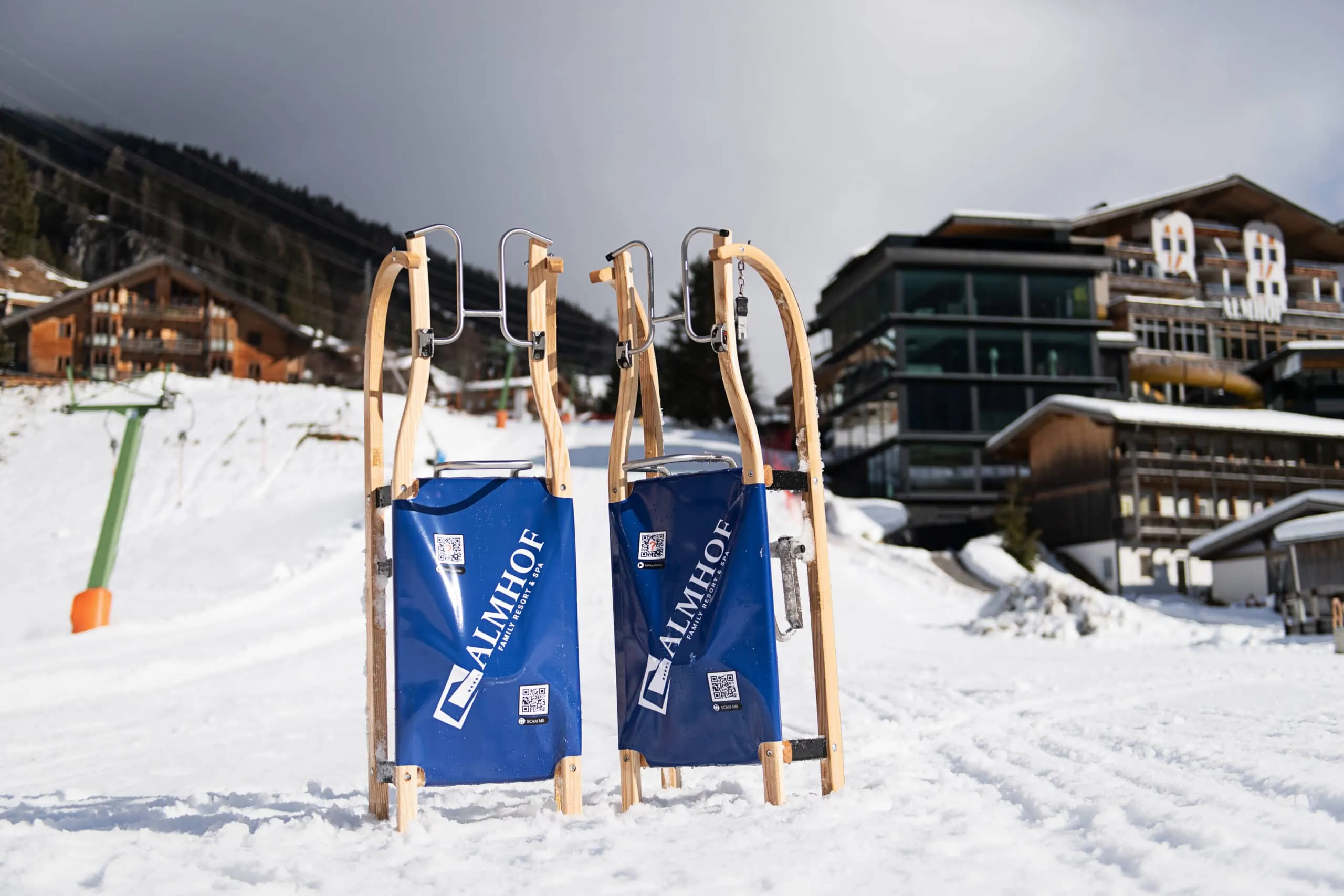 Schlitten im Schnee vor modernen Hütten