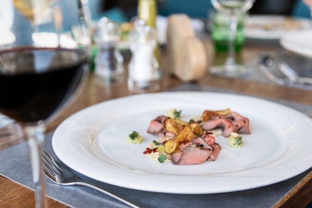 Leckeres Gericht mit Rotwein und Beilagen.