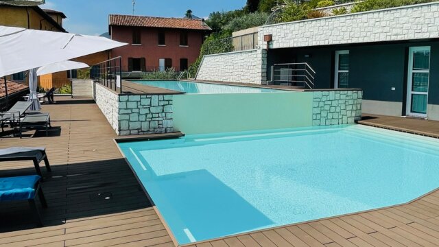 Moderne Poollandschaft mit Terrasse und Sonnenschirmen