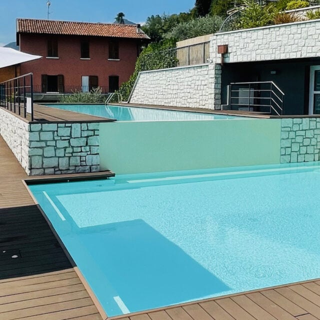 Moderne Poollandschaft mit Terrasse und Sonnenschirmen