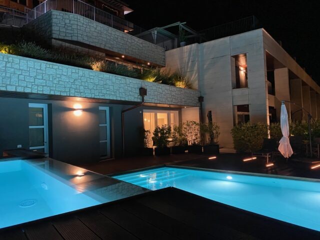 Moderne Architektur mit beleuchtetem Pool bei Nacht