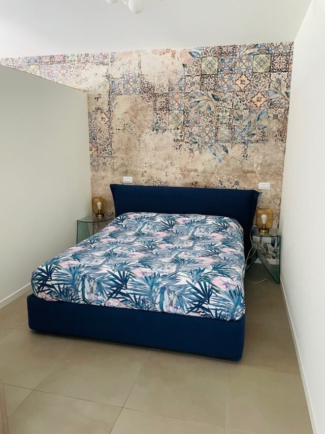 Modernes Schlafzimmer mit floralem Bettbezug.