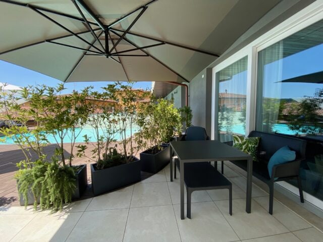 Gemütlicher Außenbereich mit Pflanzen und Poolblick