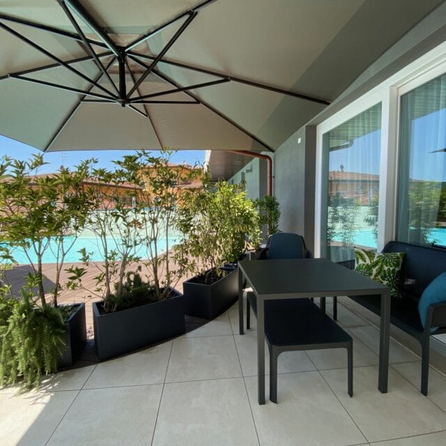 Gemütlicher Außenbereich mit Pflanzen und Poolblick