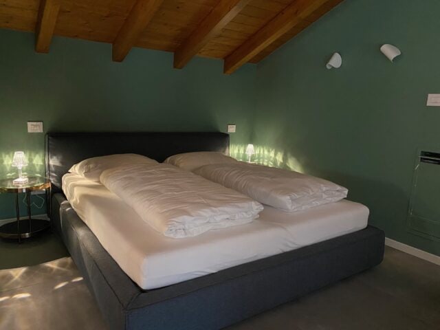 Modernes Schlafzimmer mit Doppelbett und Nachttischlampe