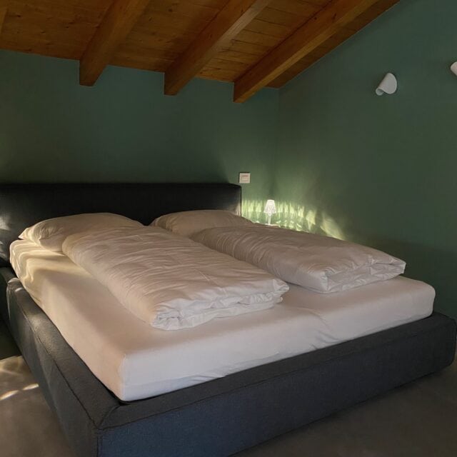 Modernes Schlafzimmer mit Doppelbett und Nachttischlampe