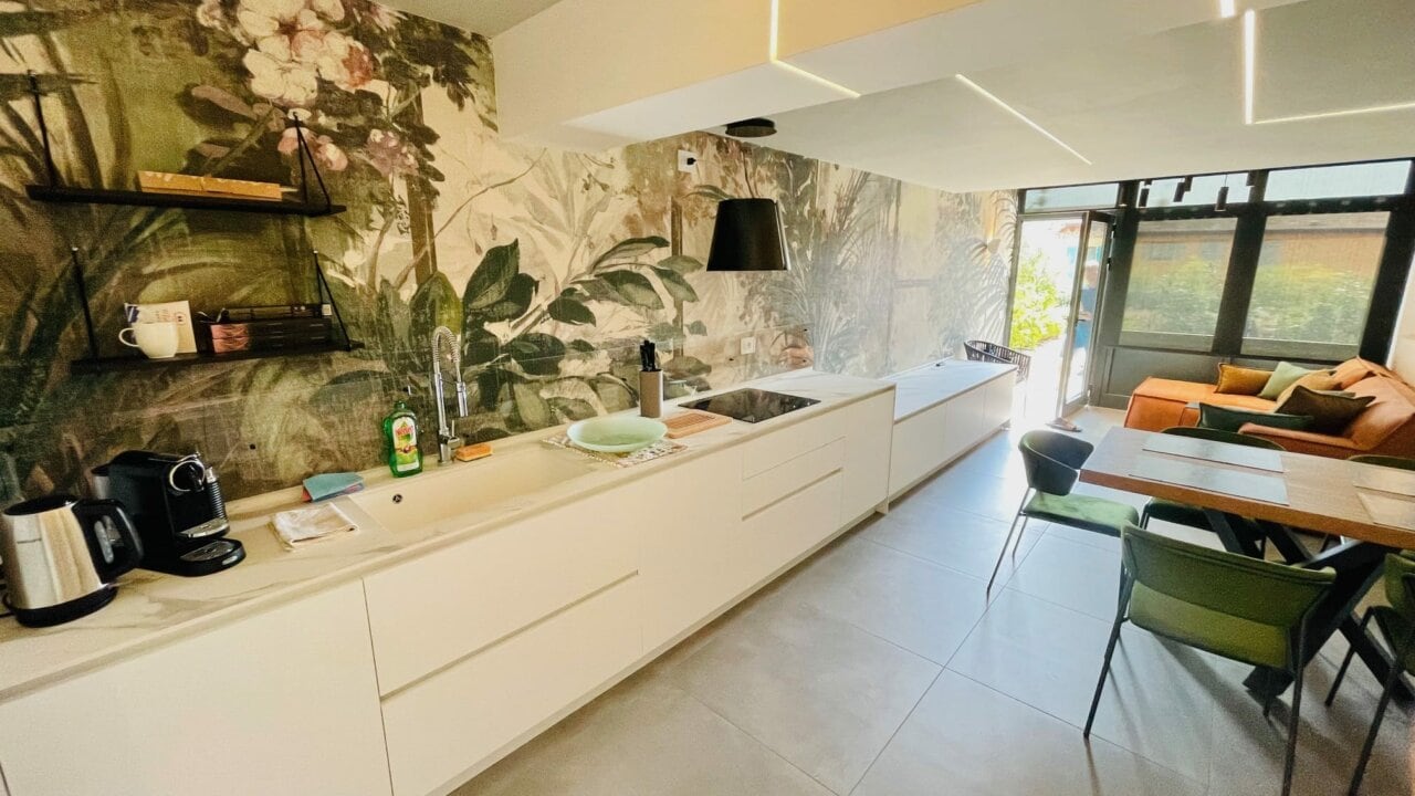 Moderne Küche mit Pflanzenwand und gemütlichem Essbereich.