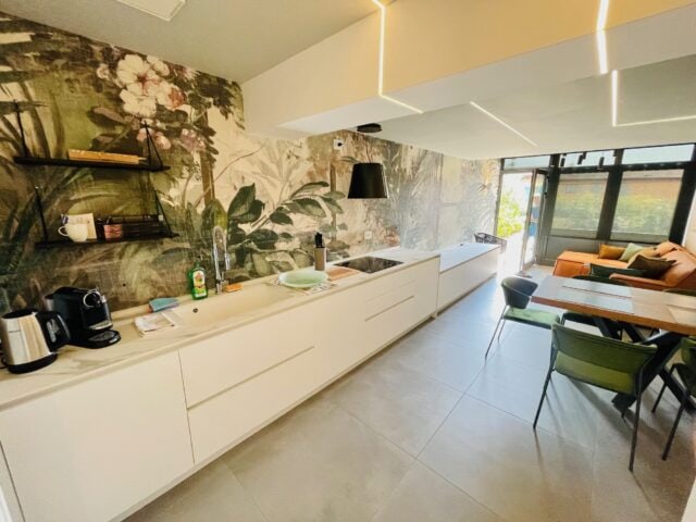 Moderne Küche mit Pflanzenwand und gemütlichem Essbereich.