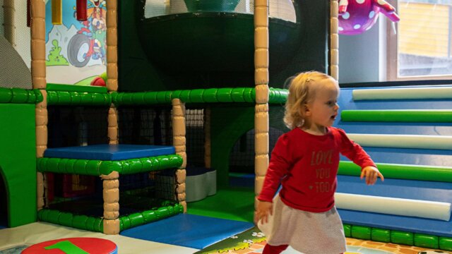 Kind spielt im bunten Indoor-Spielbereich.