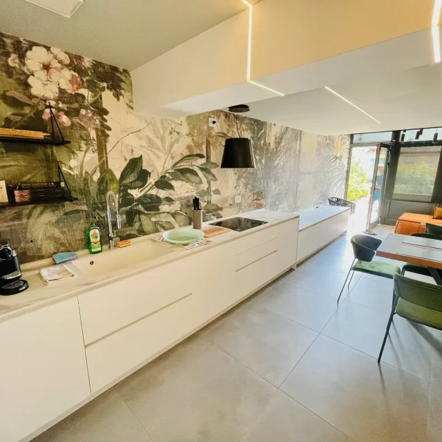 Moderne Küche mit Pflanzenwand und gemütlichem Essbereich.