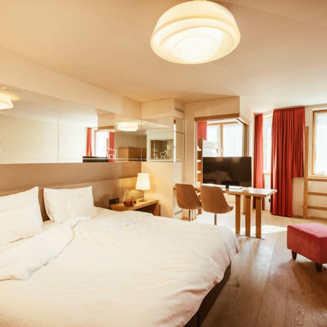 Helles Zimmer mit Bett und TV-Bereich