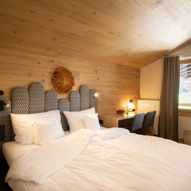 Gemütliches Schlafzimmer mit Holzwänden und Aussicht