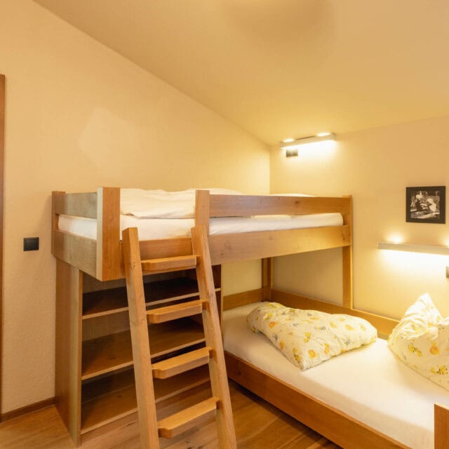 Gemütliches Schlafzimmer mit Hochbett und Holzdetails