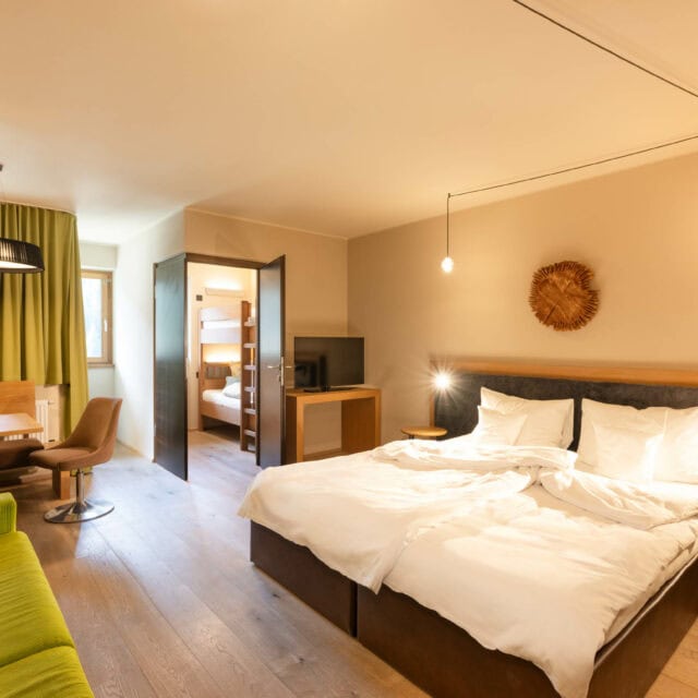 Gemütliches Hotelzimmer mit Möbeln und Fenstern.
