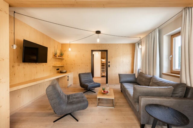 Modernes Wohnzimmer mit Holzwänden und Möbeln