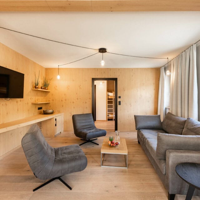 Modernes Wohnzimmer mit Holzwänden und Möbeln