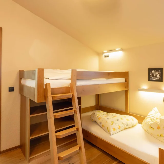 Gemütliches Schlafzimmer mit Hochbett und Holzdetails