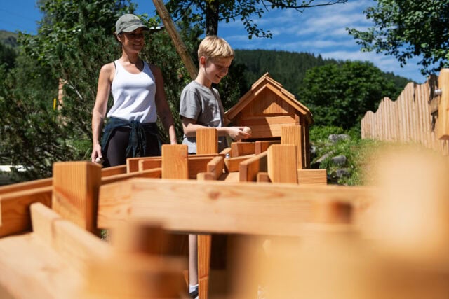 Erwachsene und Kind beim Spielen im Freien.