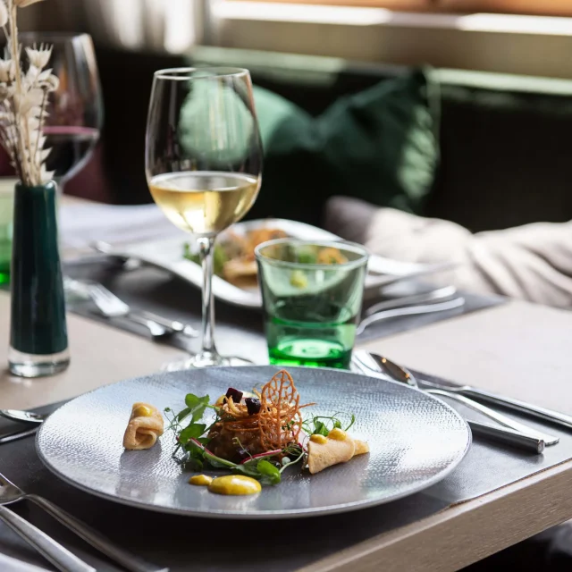 Gourmetgericht mit Wein und dekorativem Besteck